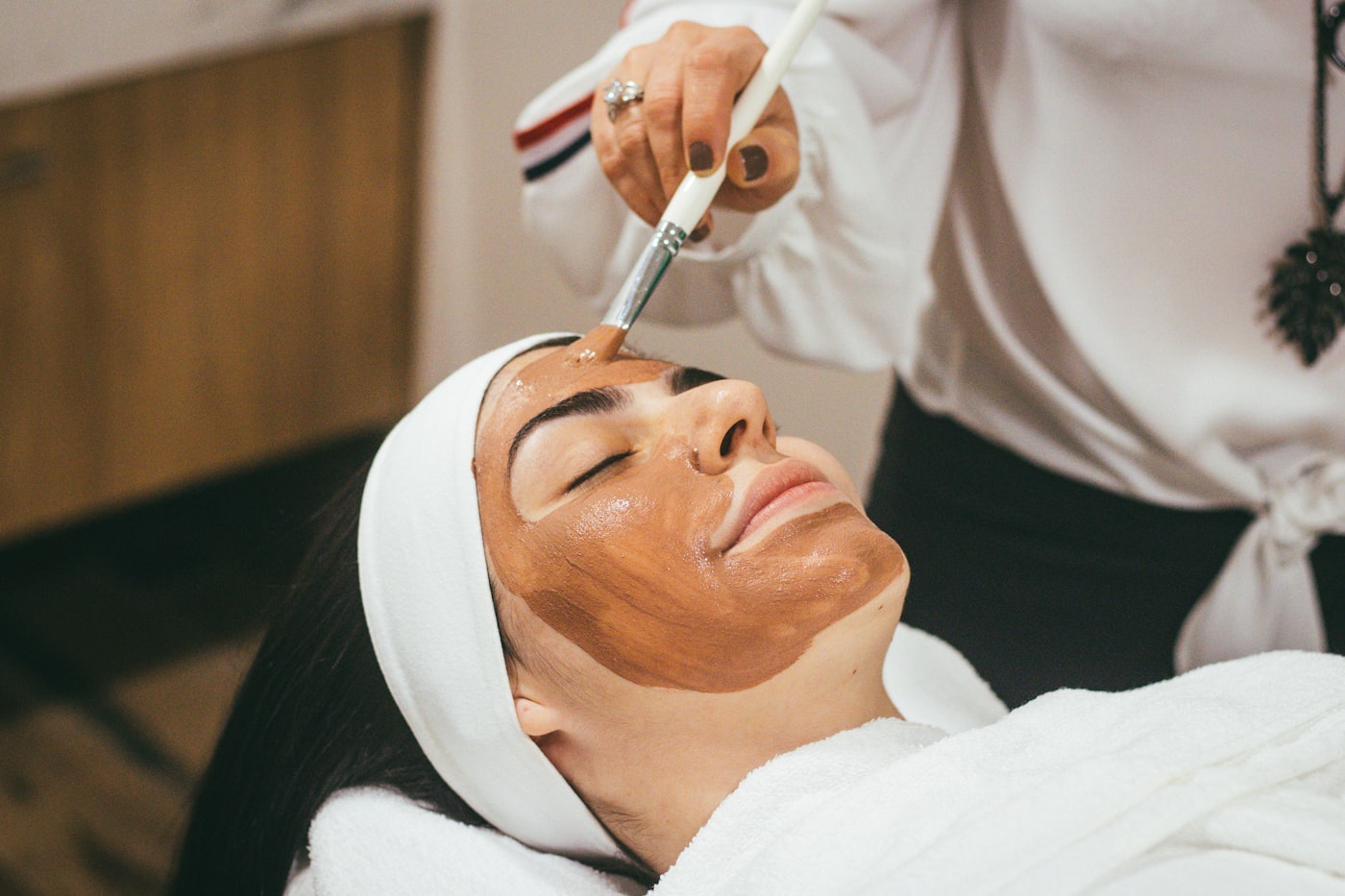 Esthetician applying a facial mask at a med spa